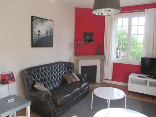 - un salon avec un canapé en cuir et une cheminée dans l'établissement Moulin du Hamelet, à Saint-Aubin-sur-Scie