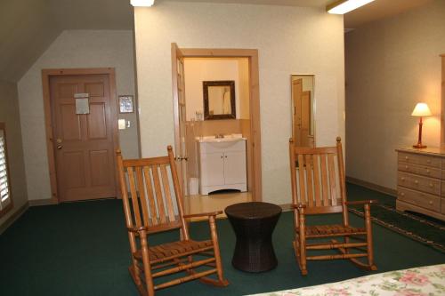 Habitación con 2 sillas de madera y lavamanos en Visions Inn, en Cooperstown