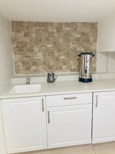 a kitchen with white cabinets and a sink at צימר בצפת, מרווח ושקט, חצר גדולה, מיועד לשומרי שבת, ישנן שתי מיטות רגילות ועוד שתיים מתקפלות, ארבע מיטות סך הכל in Safed