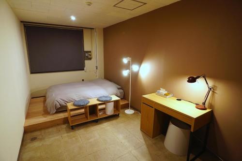 a bedroom with a bed and a desk and a projection screen at La Union in Fukushima