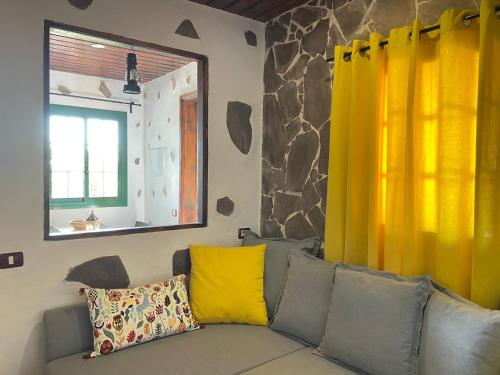 a living room with a couch with yellow curtains at Casa Arrantzale II in El Cercado