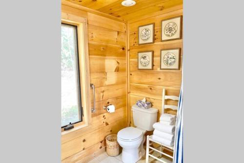 a bathroom with a toilet and wooden walls at Harvest Moon Loft in Sylva