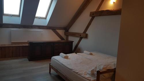 a bedroom with a bed in a attic at Dziewanna in Brzeziniec