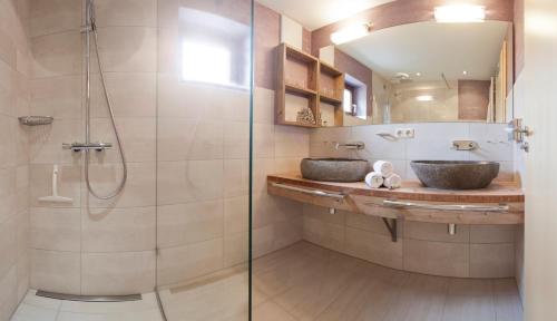 a bathroom with two sinks and a shower at Denninger's Ferienhäusle in Riezlern