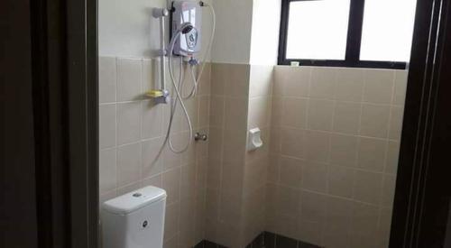a bathroom with a shower with a toilet and a shower head at Homestay Lot 10 Pangkor in Pangkor