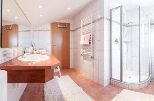 a bathroom with a sink and a shower at Denninger's Ferienhäusle in Riezlern