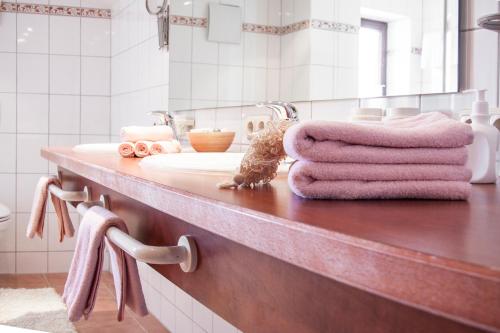 a bathroom with a sink with pink towels on it at Denninger's Ferienhäusle in Riezlern