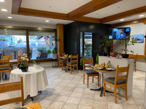 a restaurant with tables and chairs and a tv at Hotel Casino in Sierre