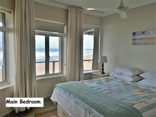 um quarto com uma cama e vista para a praia em Omega apartment em Jeffreys Bay