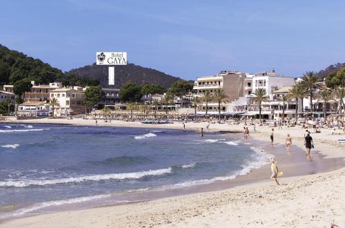 a group of people on a beach near the ocean at Hotel Gaya in Paguera