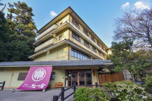 a building with a pink sign in front of it at Miyajima Morinoyado in Miyajima