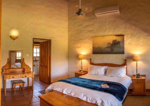 a bedroom with a bed and a table and a piano at Mount Ceder in Cederberg