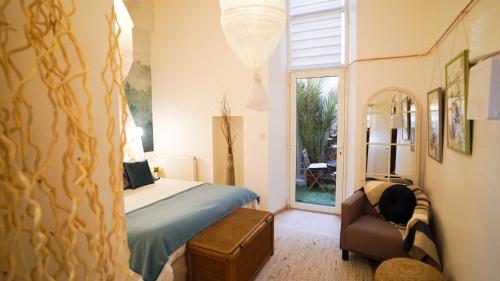 um quarto com uma cama, uma cadeira e uma janela em La Lavandière upcycling, confort, fibre BedinShop em Romans-sur-Isère