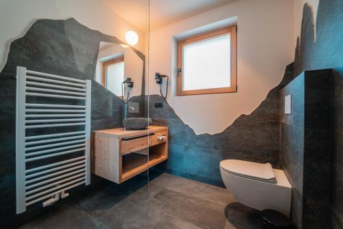 a bathroom with a toilet and a sink at Kierhof Chalets in Velturno