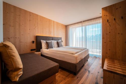 a hotel room with a bed and a window at Kierhof Chalets in Velturno