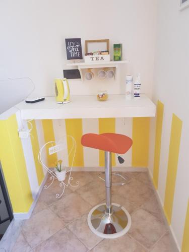 a desk with a red stool in a room at B&B Dimora del centro in Scalea