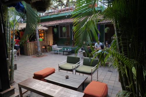 un patio con sillas, una mesa y gente sentada en Jungle by sturmfrei Vagator en Vagator