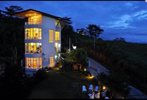 a large white building with lights on it at night at Kandyan View Holiday Bungalow free pickup from kandy in Kandy