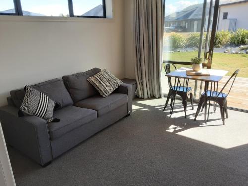 a living room with a couch and a table with chairs at Two Thumbs Unit 2 in Lake Tekapo