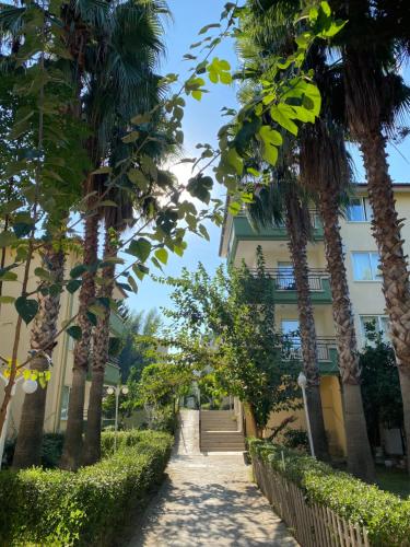 a path in front of a building with palm trees at Melissa Garden Apart Hotel in Side