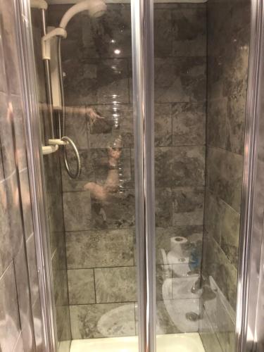 um chuveiro com uma porta de vidro na casa de banho em Sea view studio em Felixstowe