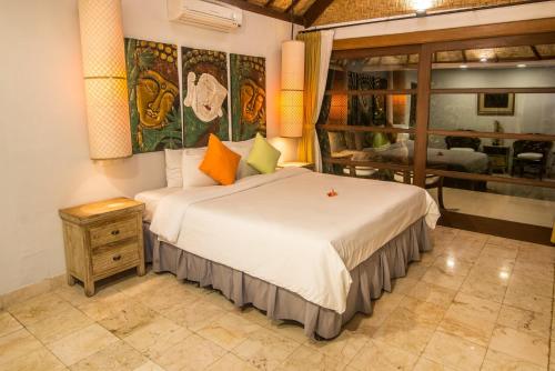a bedroom with a large bed and a table at Bali Santi Bungalows in Candidasa