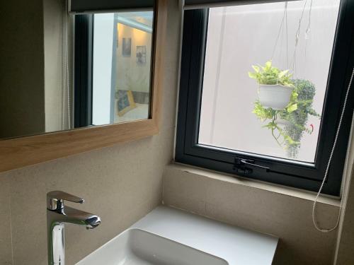 a bathroom with a sink and a window with a potted plant at VISION HOTEL in Phan Rang