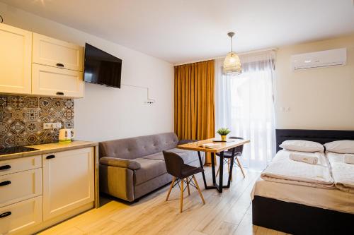 uma cozinha e uma sala de estar com uma cama e uma mesa em Apartamenty Homole em Szczawnica