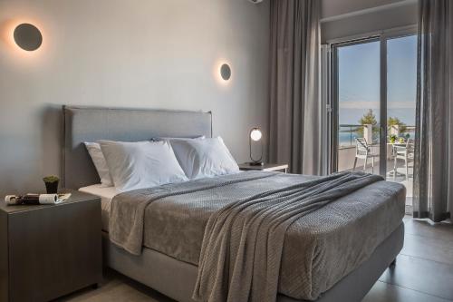 a bedroom with a bed with a view of the ocean at Limanaki Hotel in Lassi