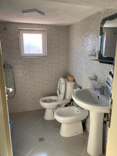 a bathroom with two toilets and a sink and a window at Syzo Rooftop 360° in Pogradec