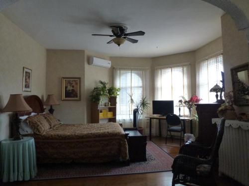 a bedroom with a bed and a ceiling fan at Auberge King Edward Bed and Breakfast in Ottawa