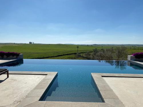 a swimming pool with a view of a field at Monte da Aparica in Galeguinha Grande