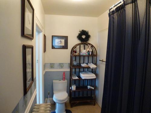 a bathroom with a toilet and a shelf with towels at Auberge King Edward Bed and Breakfast in Ottawa