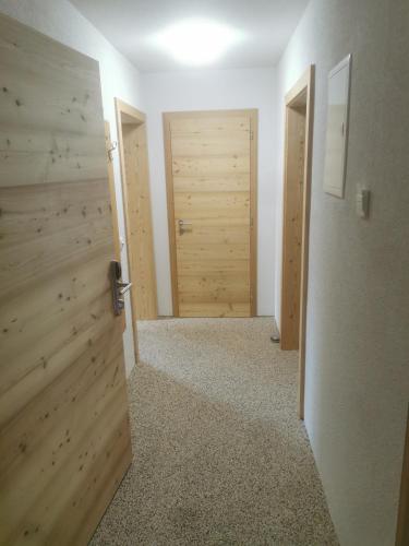 an empty room with two doors and a hallway at Gästehaus Obererlacher in Obertilliach
