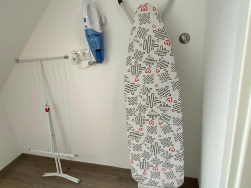 a surfboard hanging on a wall next to a broom at Time Out Apartments in Herzogenaurach