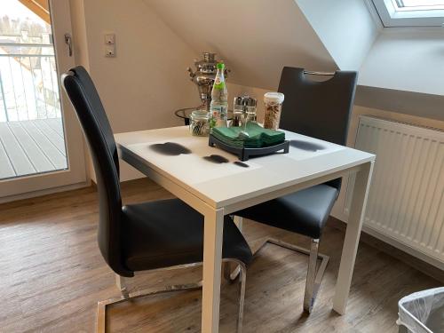 a dining room table with two chairs and a white table at Time Out Apartments in Herzogenaurach