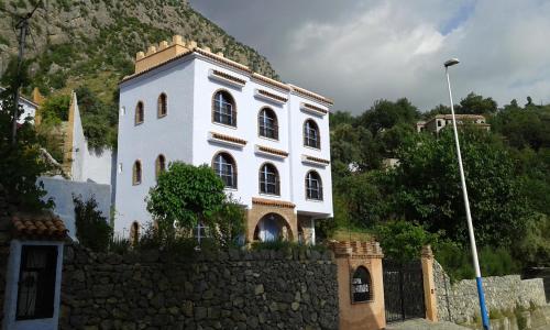 a white building on top of a stone wall at Hotel Alkhalifa in Chefchaouen