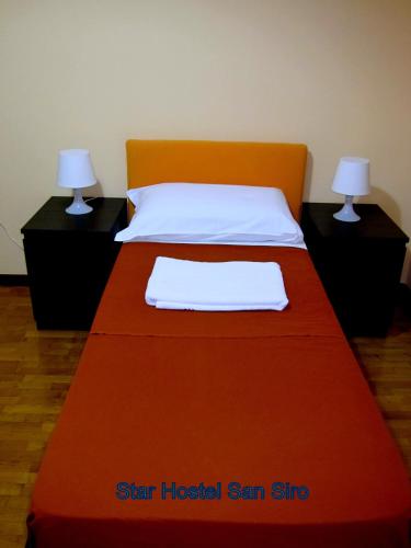 a bed with an orange headboard and two night stands at Star Hostel San Siro Fiera in Milan