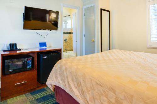 a bedroom with a bed and a flat screen tv at Travelodge by Wyndham by Fisherman's Wharf in San Francisco