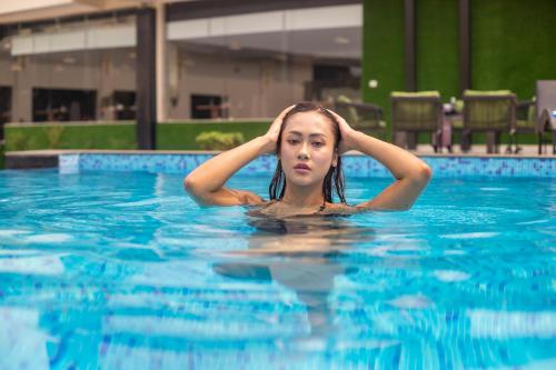 Hotel Da Flamingo في Butwāl: امرأة تسبح في المسبح