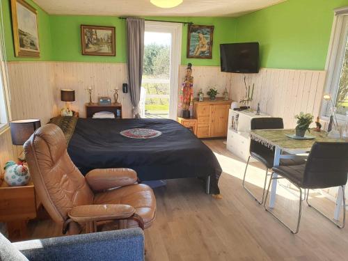 洛肯的住宿－Feriehytten Hønsehuset，一间卧室设有绿色的墙壁、一张床和一张桌子