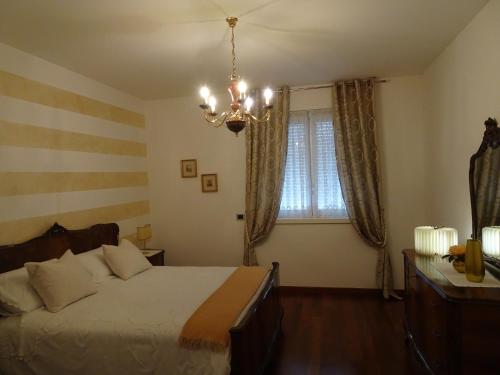 a bedroom with a large bed and a chandelier at CasaRò in Albano SantʼAlessandro