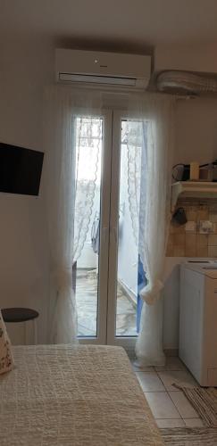 a bedroom with a bed and a sliding glass door at La Playa Studio Best location close to the Beach & center in Platis Yialos Mykonos