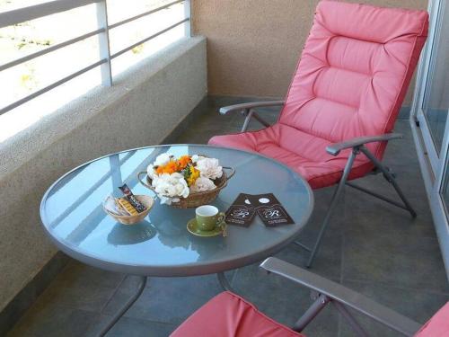 a table and a pink chair with a bowl of food on it at Apart las Rastras talca in Talca