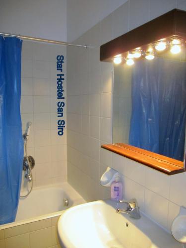 a bathroom with a sink and a mirror and a tub at Star Hostel San Siro Fiera in Milan