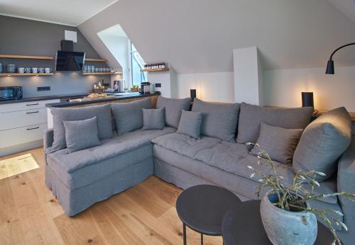 un soggiorno con un grande divano e una cucina di Julie´s Home (Penthouse) a Niendorf