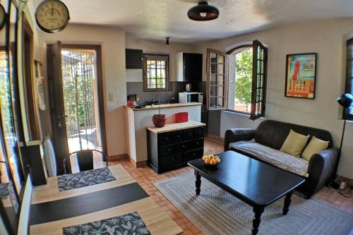 un salon avec un canapé et une table dans l'établissement Charmant 2 pièces + terrasse entouré de verdure, à Vence