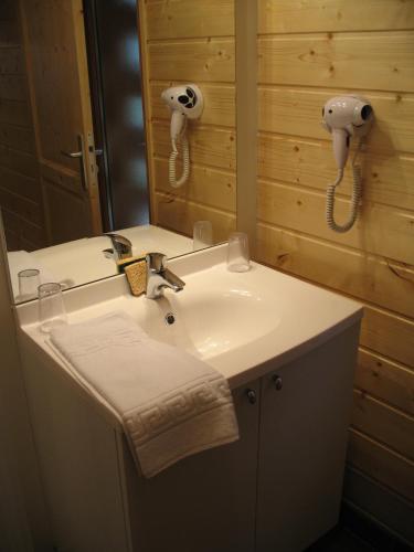 La salle de bains est pourvue d'un lavabo avec miroir et d'un téléphone. dans l'établissement Les Loges du Jura 4 étoiles, à Prénovel