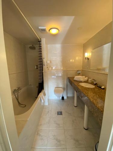 a bathroom with a sink, toilet and bathtub at Hotel Bridges House Delft in Delft