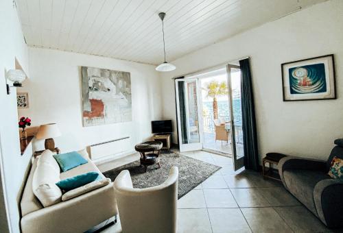 ein Wohnzimmer mit einem Sofa und einem Tisch in der Unterkunft Apartments Posta al Lago in Ronco sopra Ascona